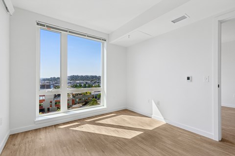 A room with a large window overlooking a cityscape.