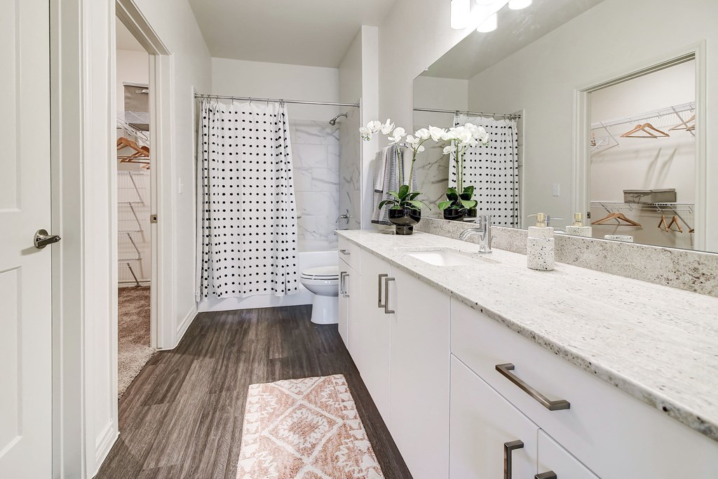 The Dylan  bathroom with white cabinets and a white shower curtain