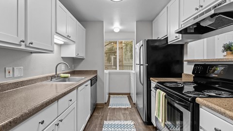 a kitchen with white cabinets and black appliances