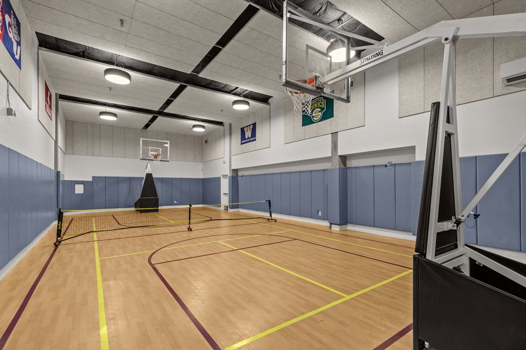 A gym with a basketball hoop and a net.