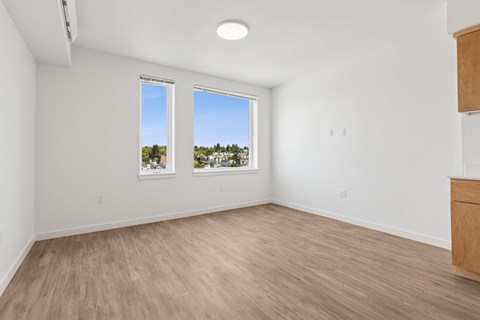 A room with a window overlooking a tree-filled landscape.