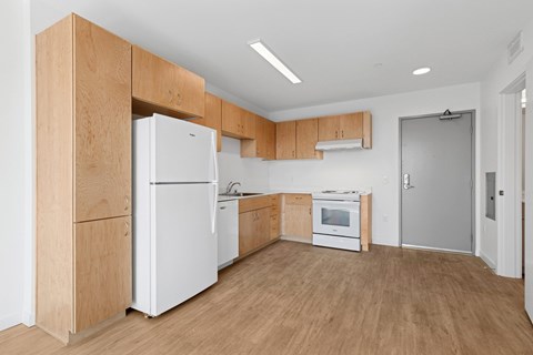A kitchen with white appliances and wooden cabinets.