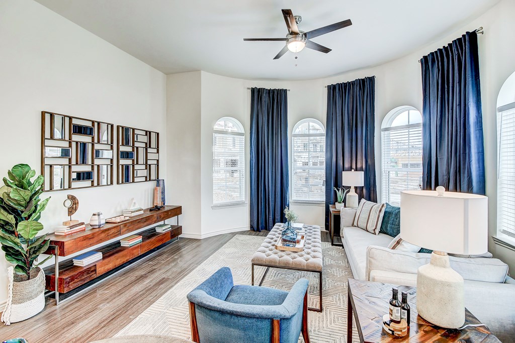 The Dylan living room with white walls and blue curtains