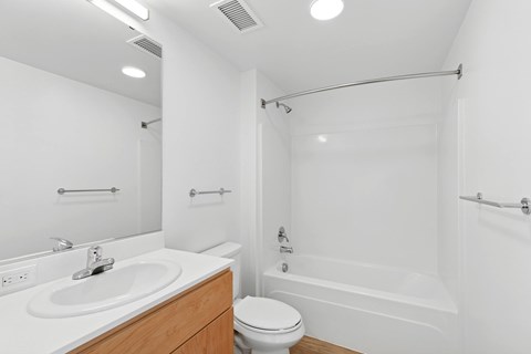 A white bathroom with a sink, toilet, and bathtub.
