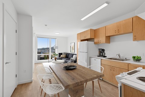 A kitchen with a table and chairs in front of a window.