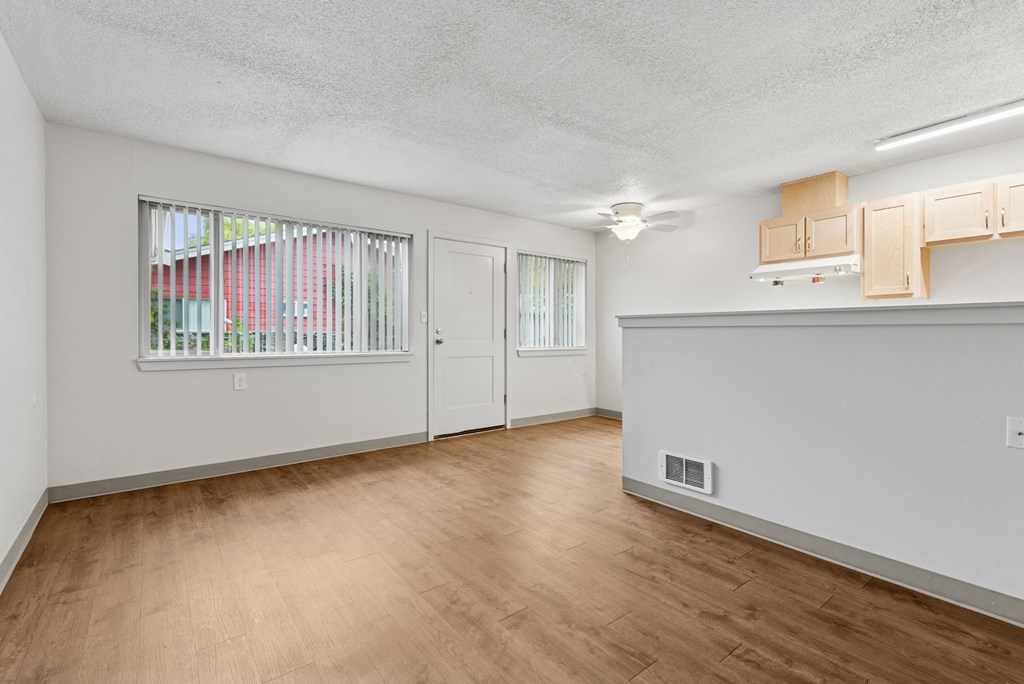 A room with a window and wooden floors.