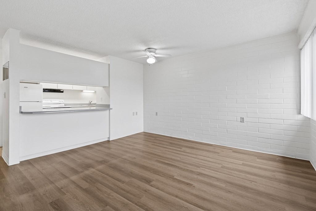 A room with wooden flooring and white walls.