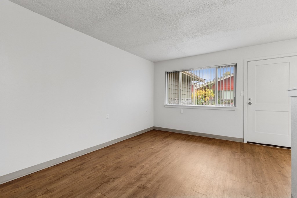 Empty room with wooden floor and white walls.