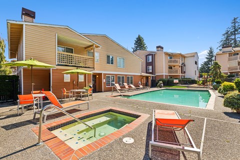 A large house with a pool and patio furniture.