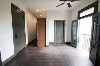 A room with a ceiling fan and wooden floors.