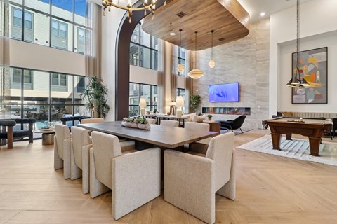 A modern dining room with a long table and chairs.