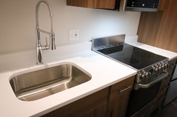 A kitchen with a stainless steel sink and oven.