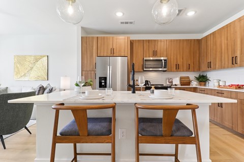 A modern kitchen with wooden cabinets and a white island.