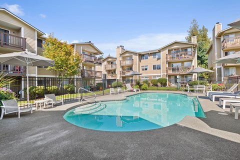 A large swimming pool in the middle of a courtyard surrounded by apartment buildings.