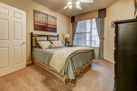 A bedroom with a bed and a window.