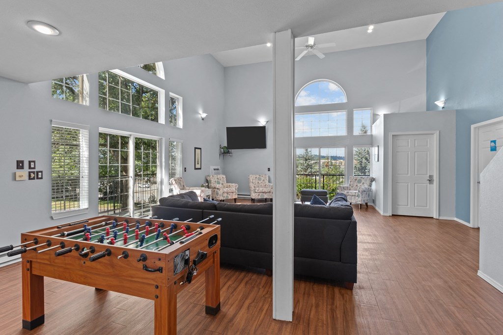 a living room with a couch and a table with a pool table
