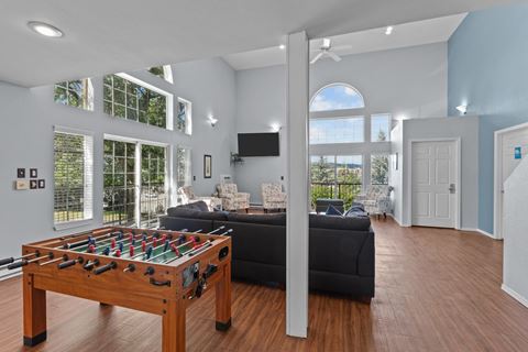 a living room with a foosball table and a black couch