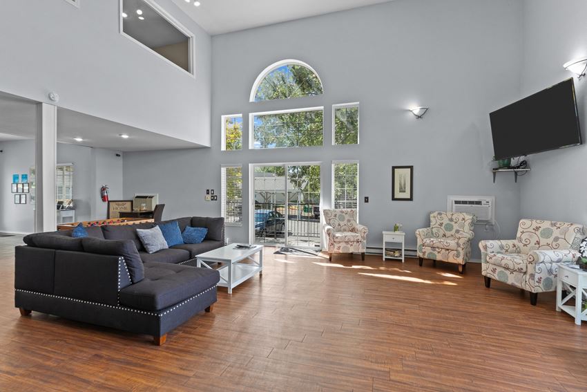 a living room with a large window and hardwood floors