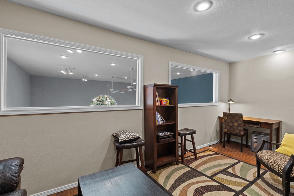 a living room with a desk and a window
