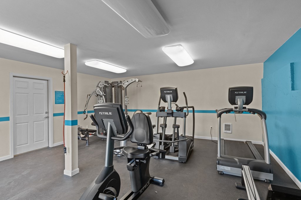 a gym with treadmills and other exercise equipment at the enclave at university heights