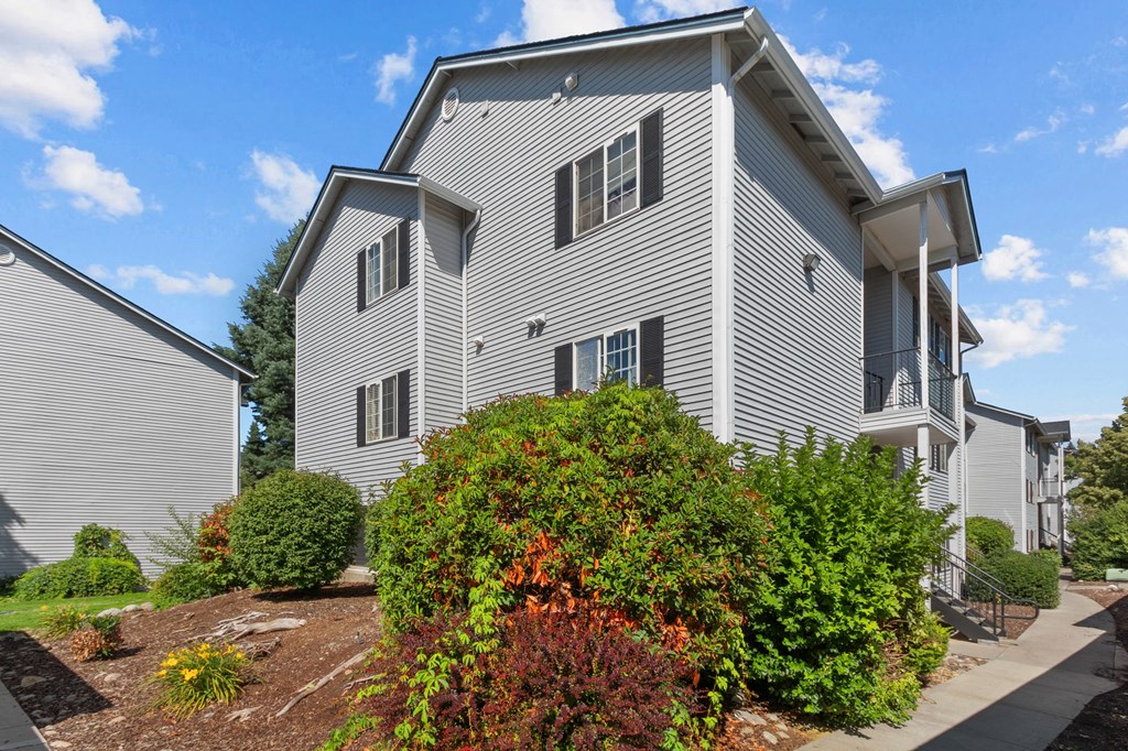 a white house with bushes in front of it
