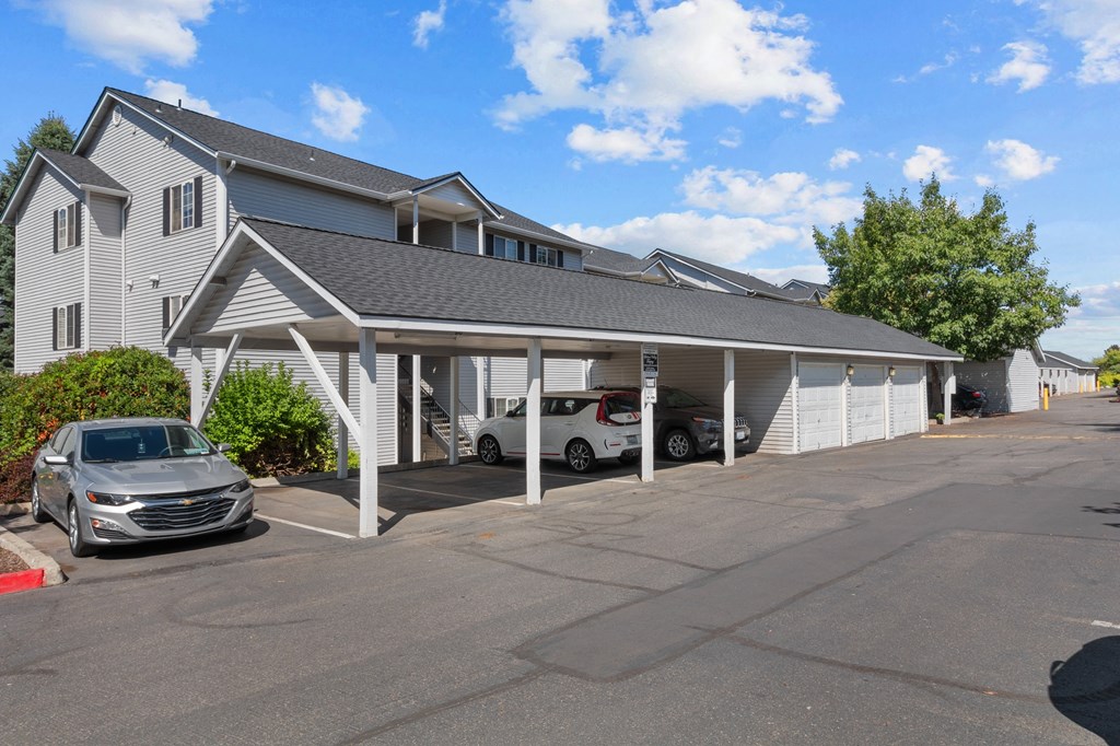 the parking lot of a motel with cars in front of it