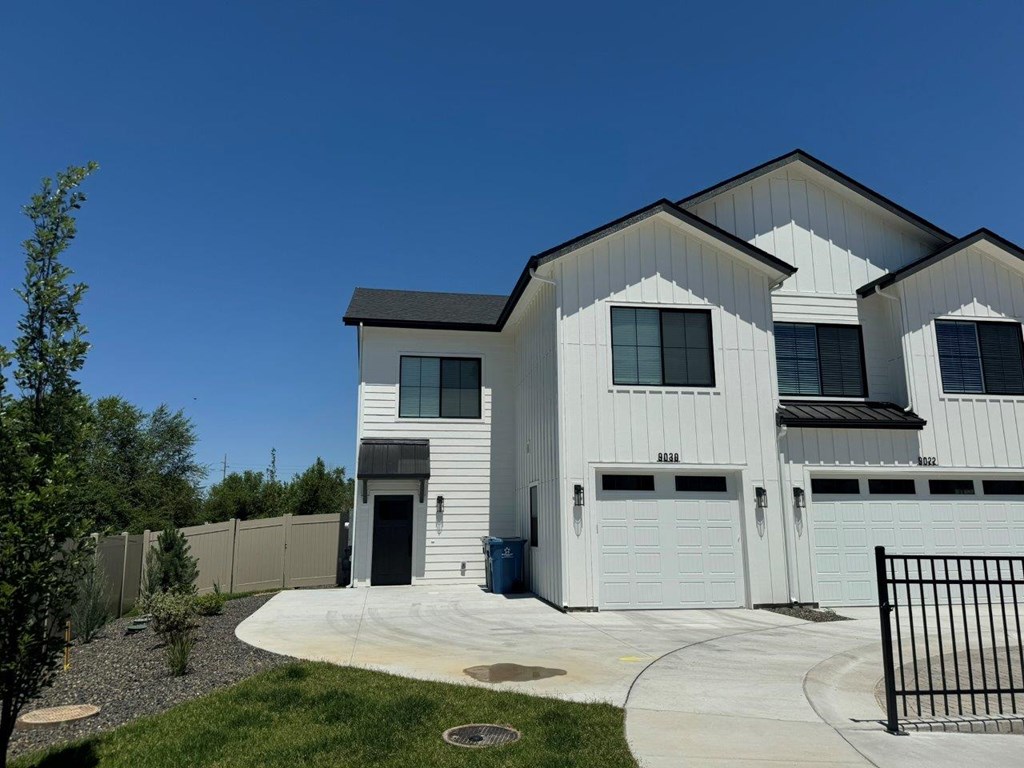 A white house with a black gate in front.