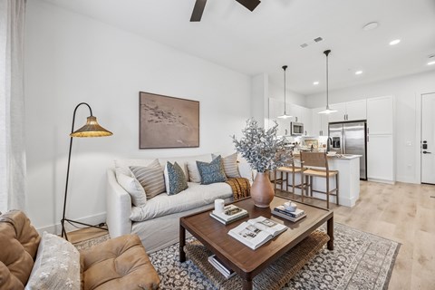 A living room with a brown leather chair and a coffee table with magazines on it.