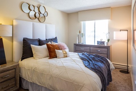 A bedroom with a large bed and a mirror on the wall.