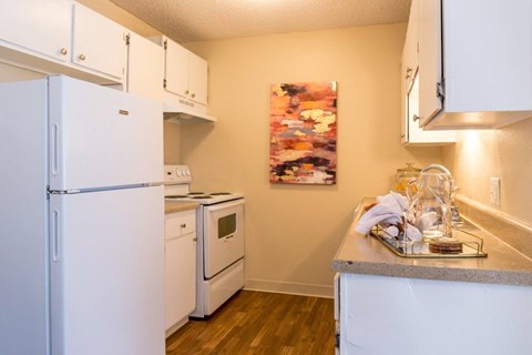 A kitchen with white appliances and a grey counter.