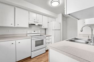a kitchen with white cabinetry and white appliances