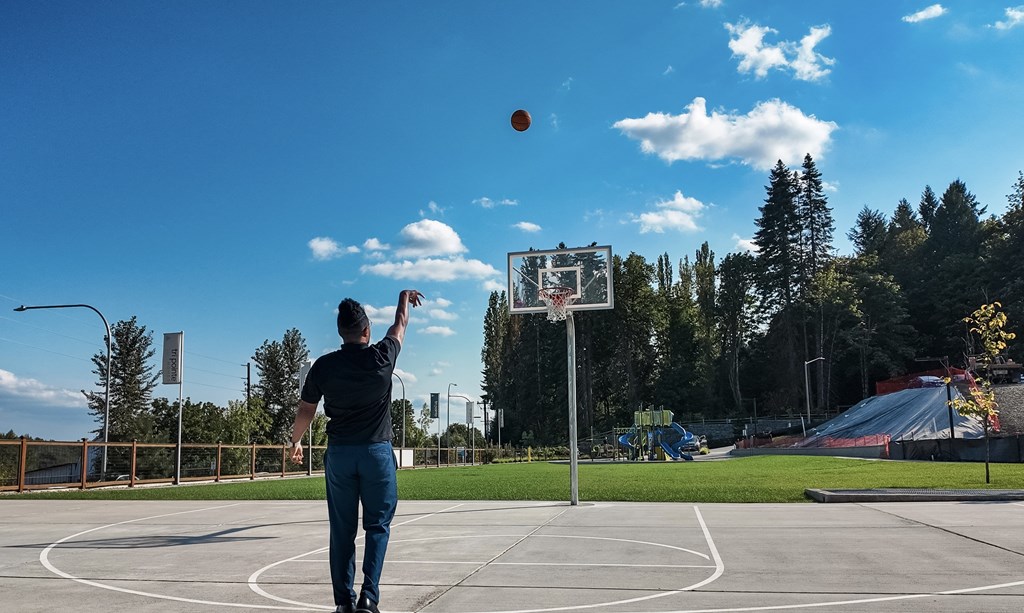 A man is playing basketball on an outdoor court.