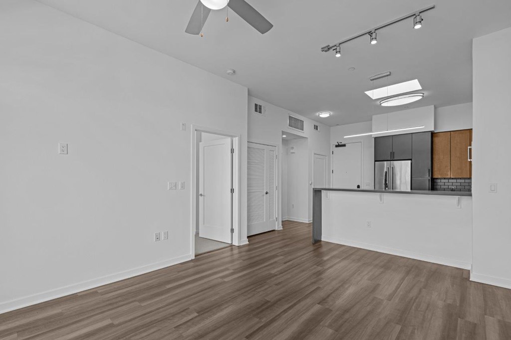 A room with a ceiling fan and track lighting.