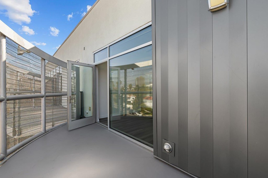 A modern building entrance with a glass door and a metal railing.