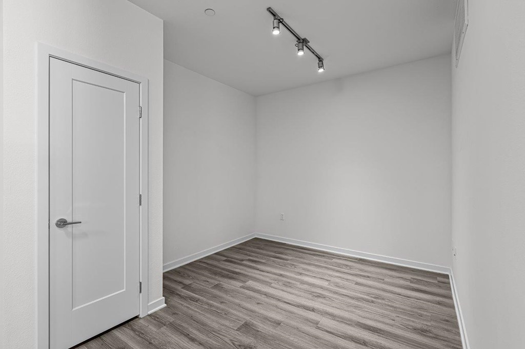 A room with a white door and a light on the ceiling.