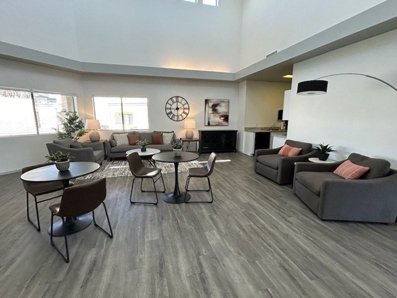 A living room with a grey sofa, a black coffee table, and a brown chair.