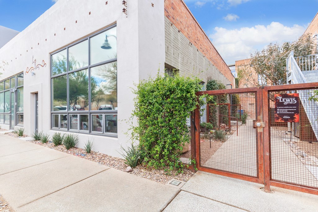 A white building with a red gate and a sign that says "LEWIS".