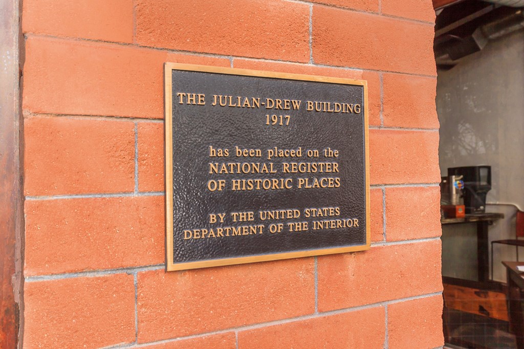 A plaque on a brick wall states that the Julian-Drew Building has been placed on the National Register of Historic Places.