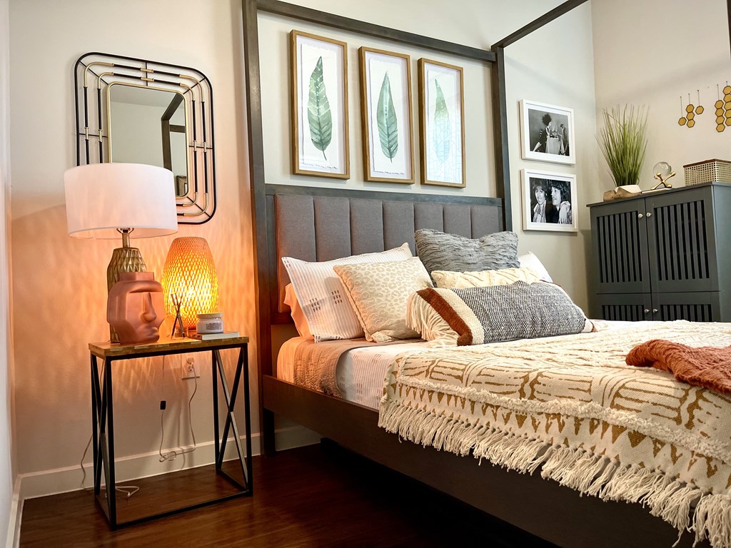 a bedroom with a bed and a lamp and pictures on the wall