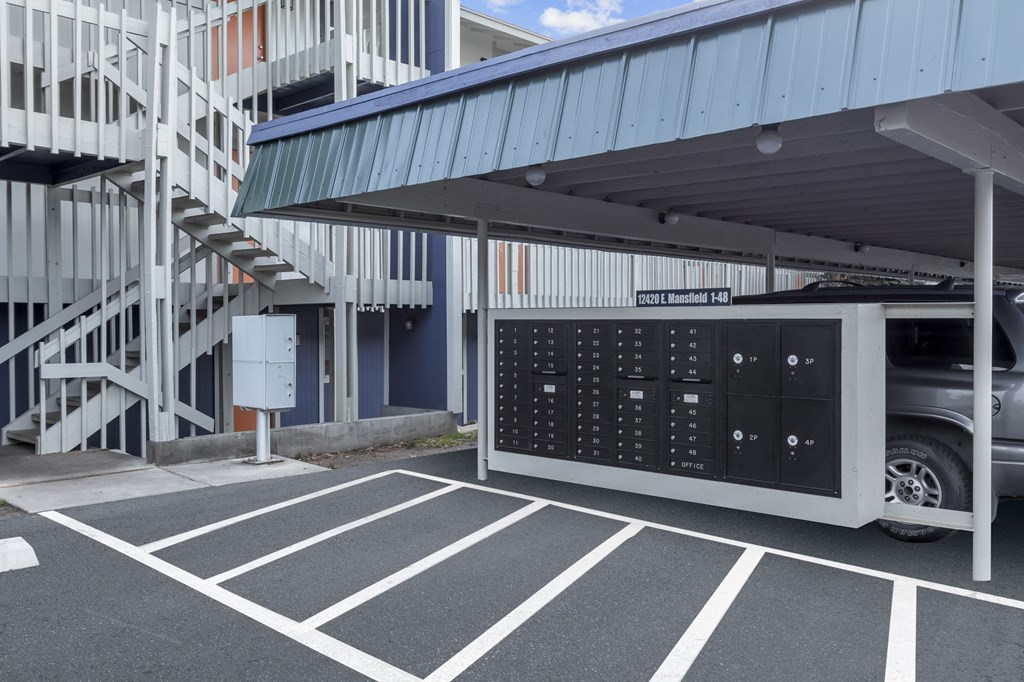 a car parked in a parking lot next to a building with a large mailbox