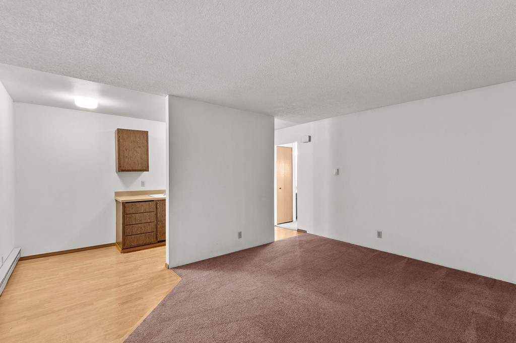 Creekside Apartments an empty living room with wood flooring and white walls