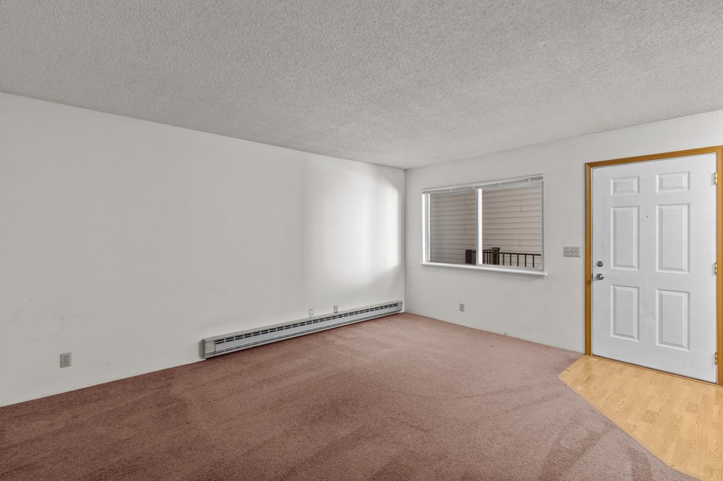Creekside Apartments an empty living room with a white door and a window