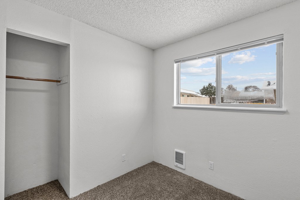 Creekside Apartments the living room of an apartment with a window and a closet