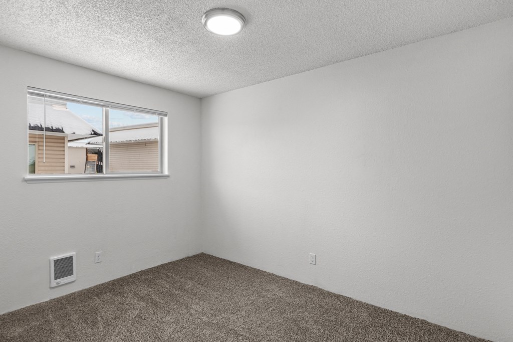 Creekside Apartments the living room of an apartment with a window and carpet