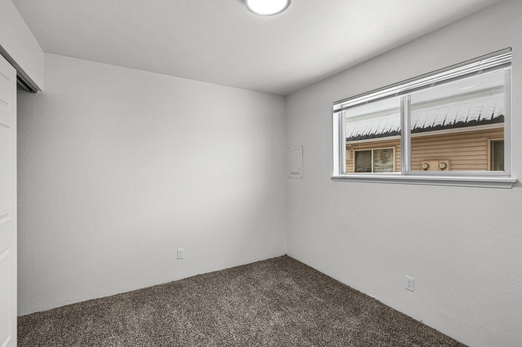 Creekside Apartments the living room of an empty home with a window and carpet
