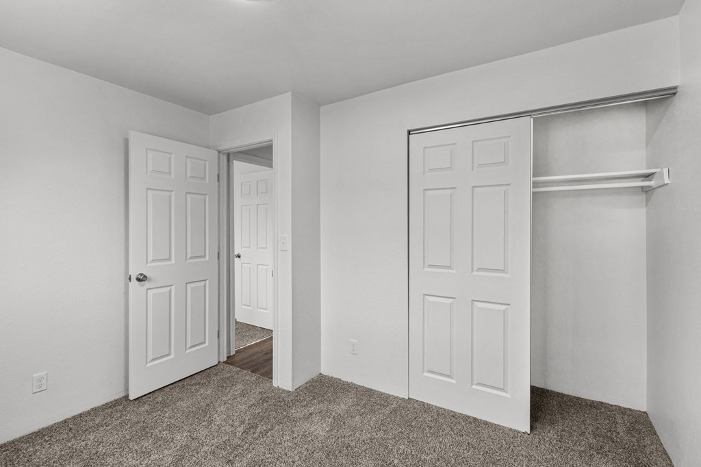 Creekside Apartments an empty bedroom with two closets and a door to a closet