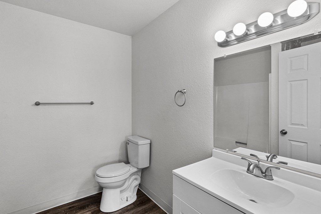 Creekside Apartments a bathroom with a toilet and a sink and a mirror