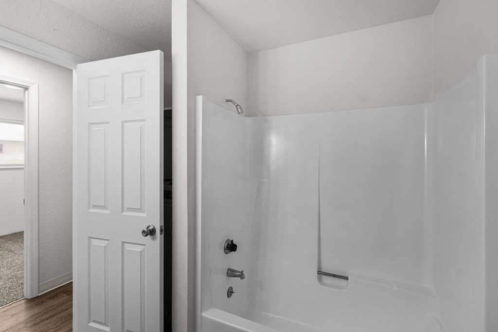 Creekside Apartments an empty bathroom with a white shower and a white door