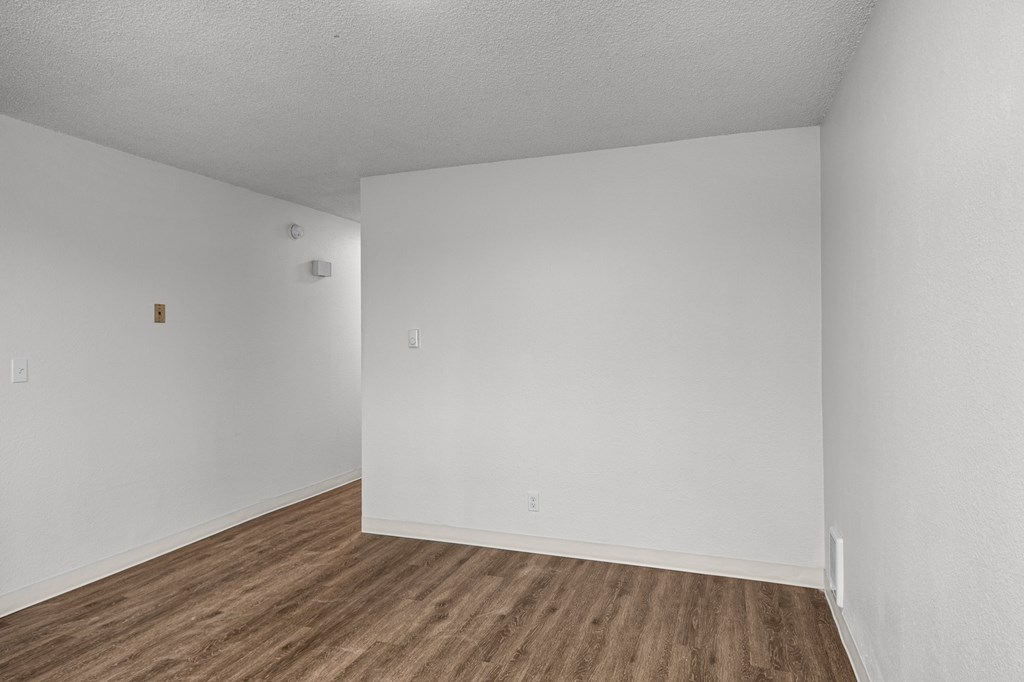 Creekside Apartments an empty room with white walls and wood flooring