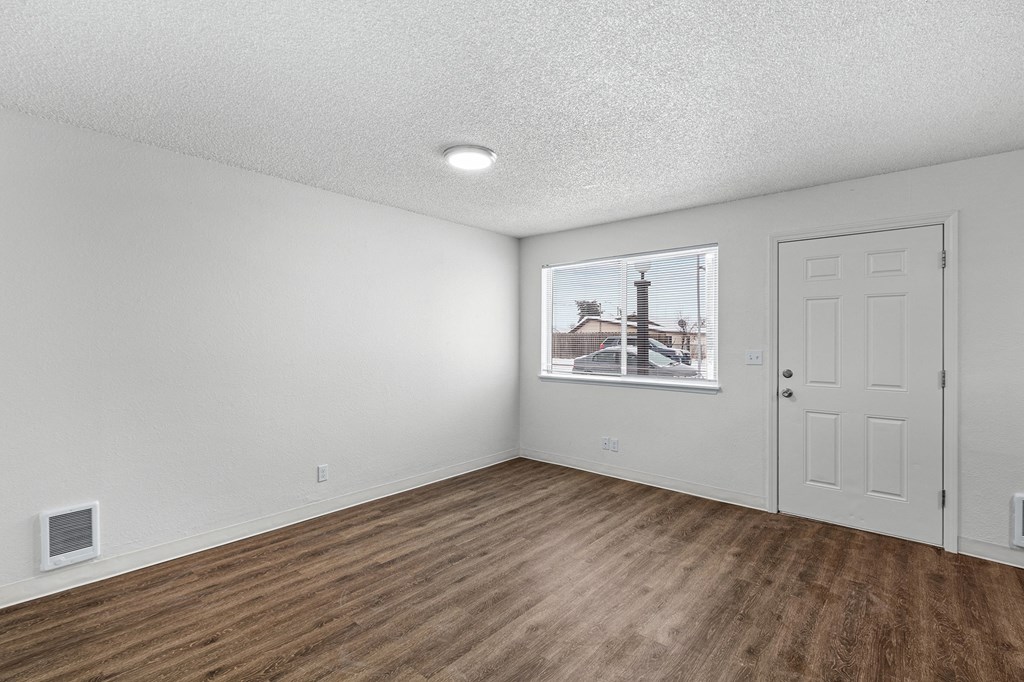 Creekside Apartments empty living room with white walls and wood flooring